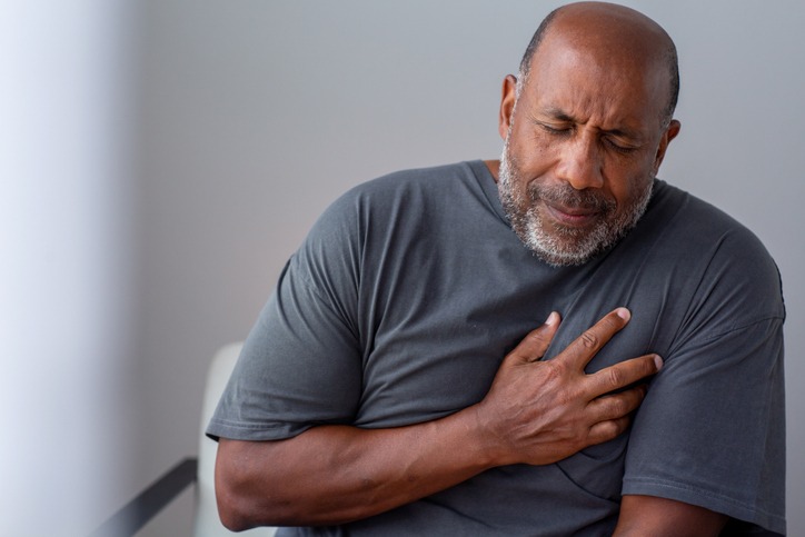 Mature man in pain holding his chest