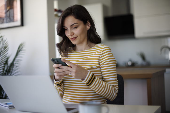 Young smiling woman using a cellphone to schedule a doctor appointment using myRiverside myChart