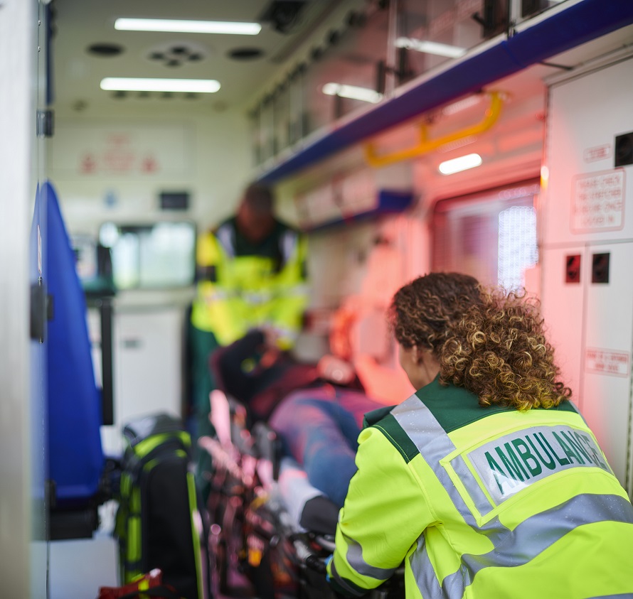 First responder helping patient into ambulance