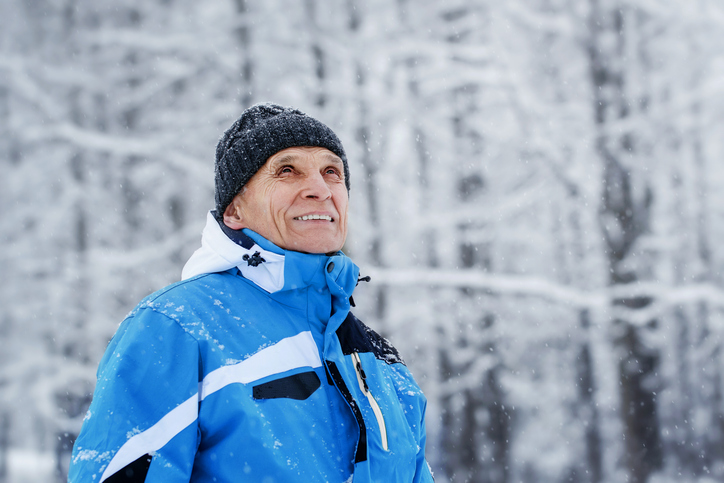 Senior man standing outside in snow