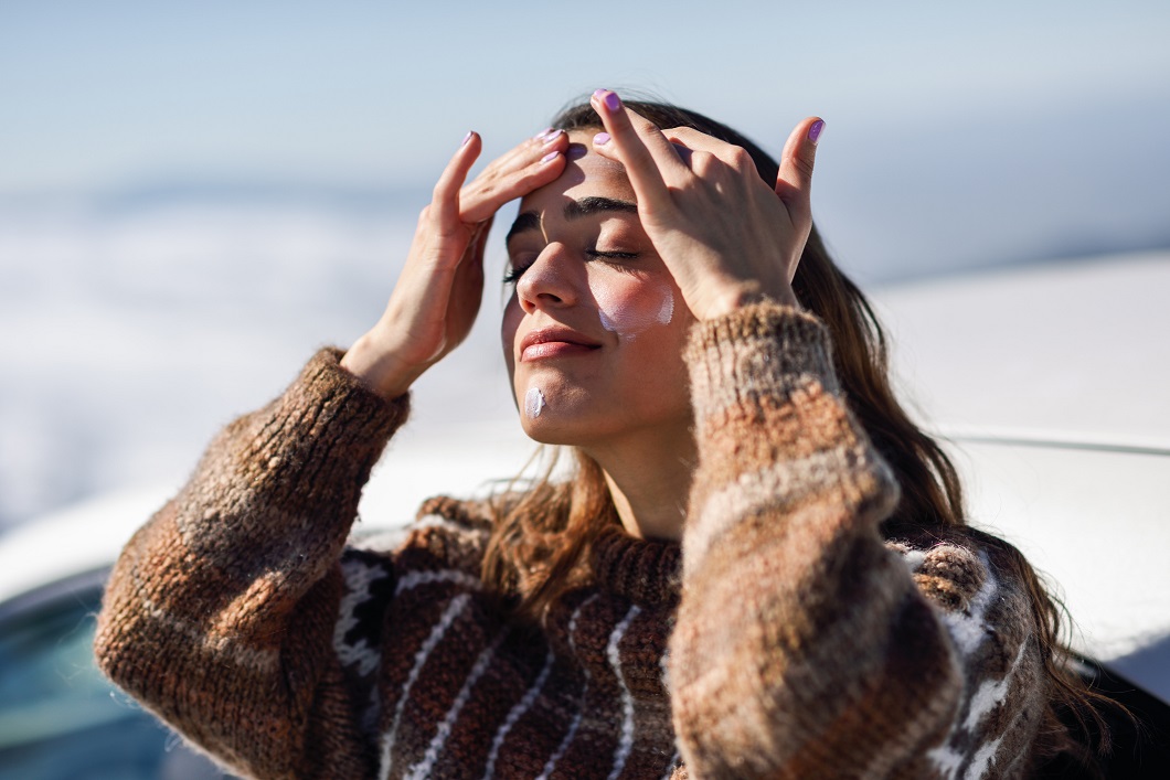Woman applies sunscreen outside in winter