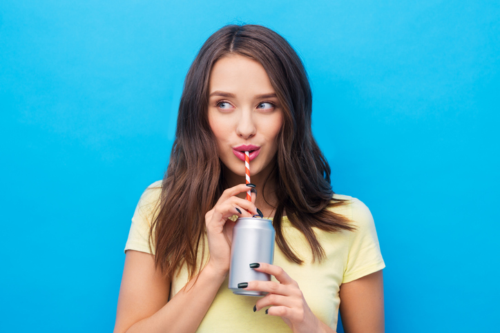 Woman drinks from a soda can