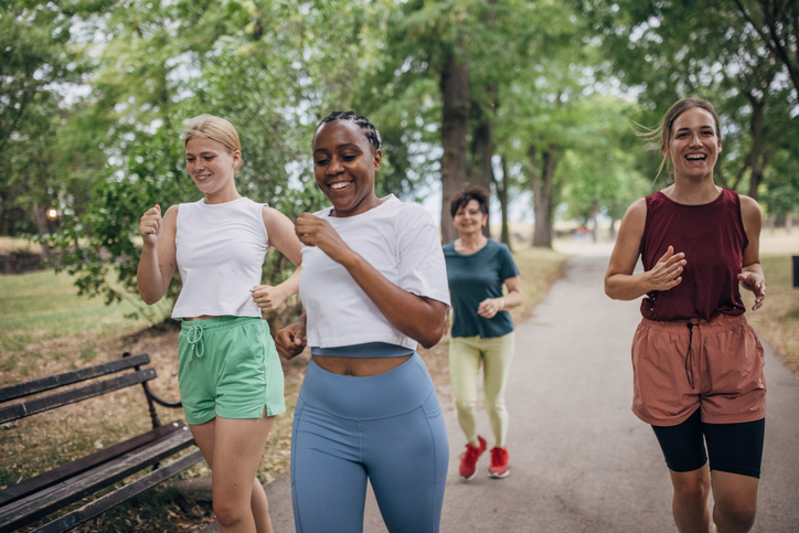 A multiracial group of women jogging on a park path
