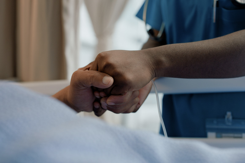 Riverside nurse holding patients hand with empathy and kindness