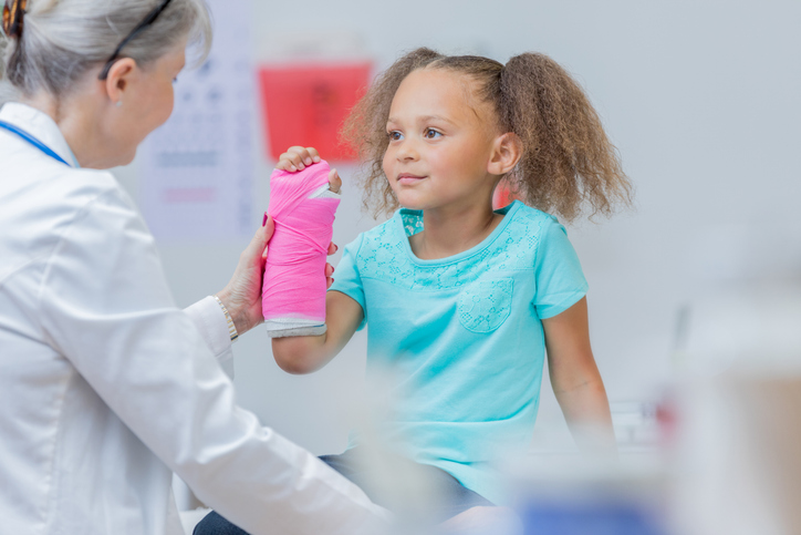 Doctor examing young girls arm