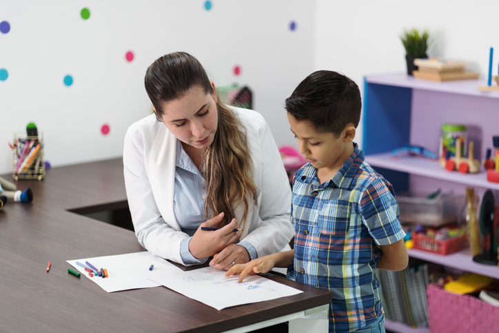 Female psychologist listening to little boy