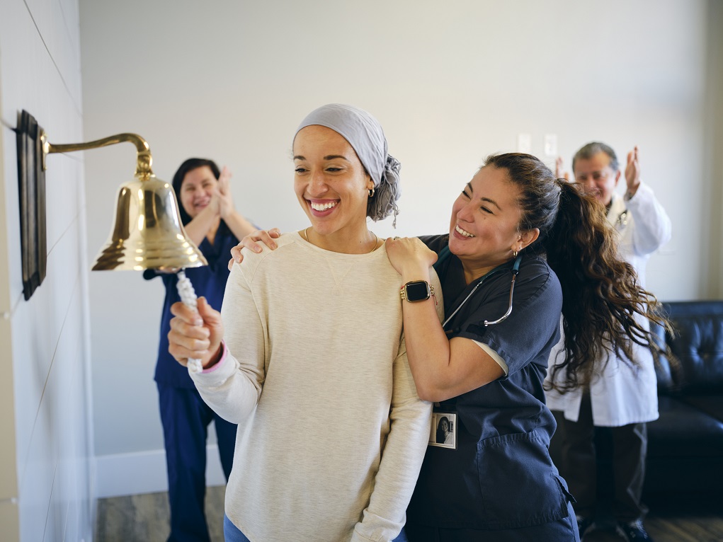 A woman rings the bell to celebrate the end of cancer treatments