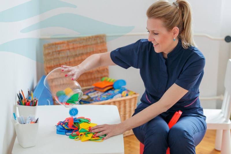 ABA Therapy Room with Provider cleaning up toys