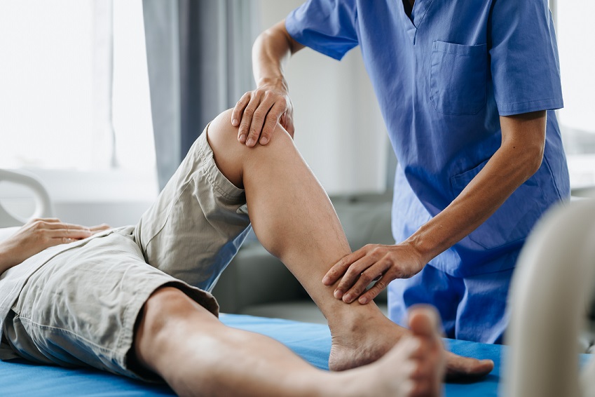 An orthopedic specialist works with the leg joints of a patient
