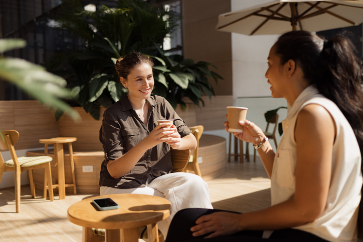 Two women chat over coffee