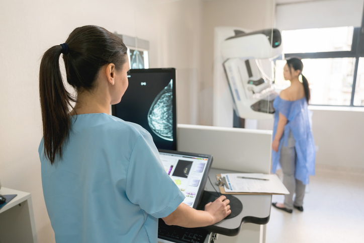nurse takes a mammogram exam with a patient