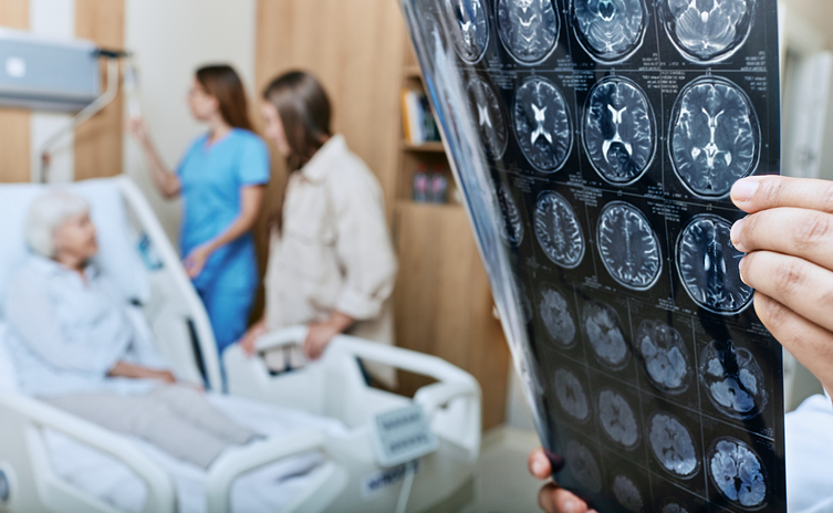 A healthcare provider reviewing an MRI of a stroke patient, with the patient and their family in the background
