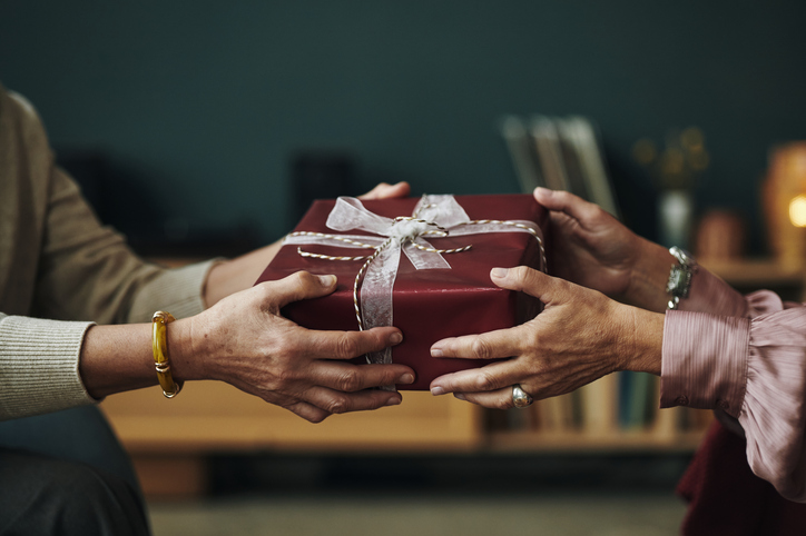 Hands giving a gift box