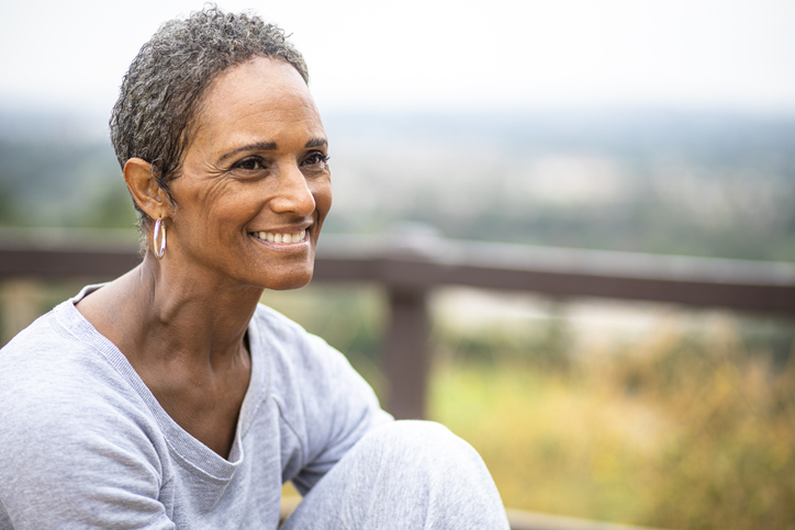 Senior woman smiling in gray