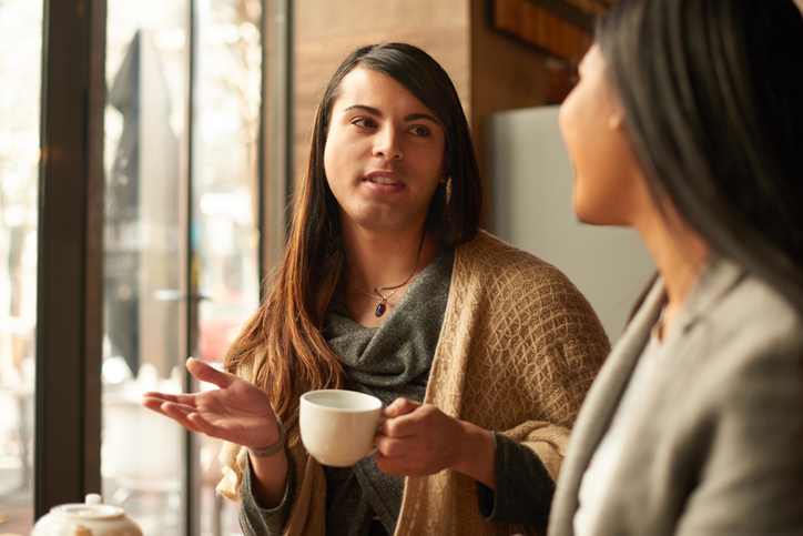 Transgender person speaking confidently and smiling during a conversation