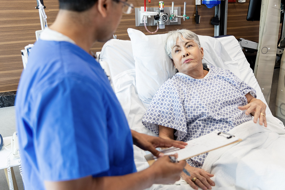 Hospitalist doctor reviewing care plan with senior patient in hospital bed