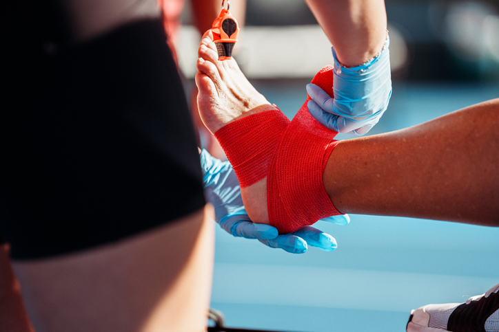 An ankle being wrapped in athletic tape