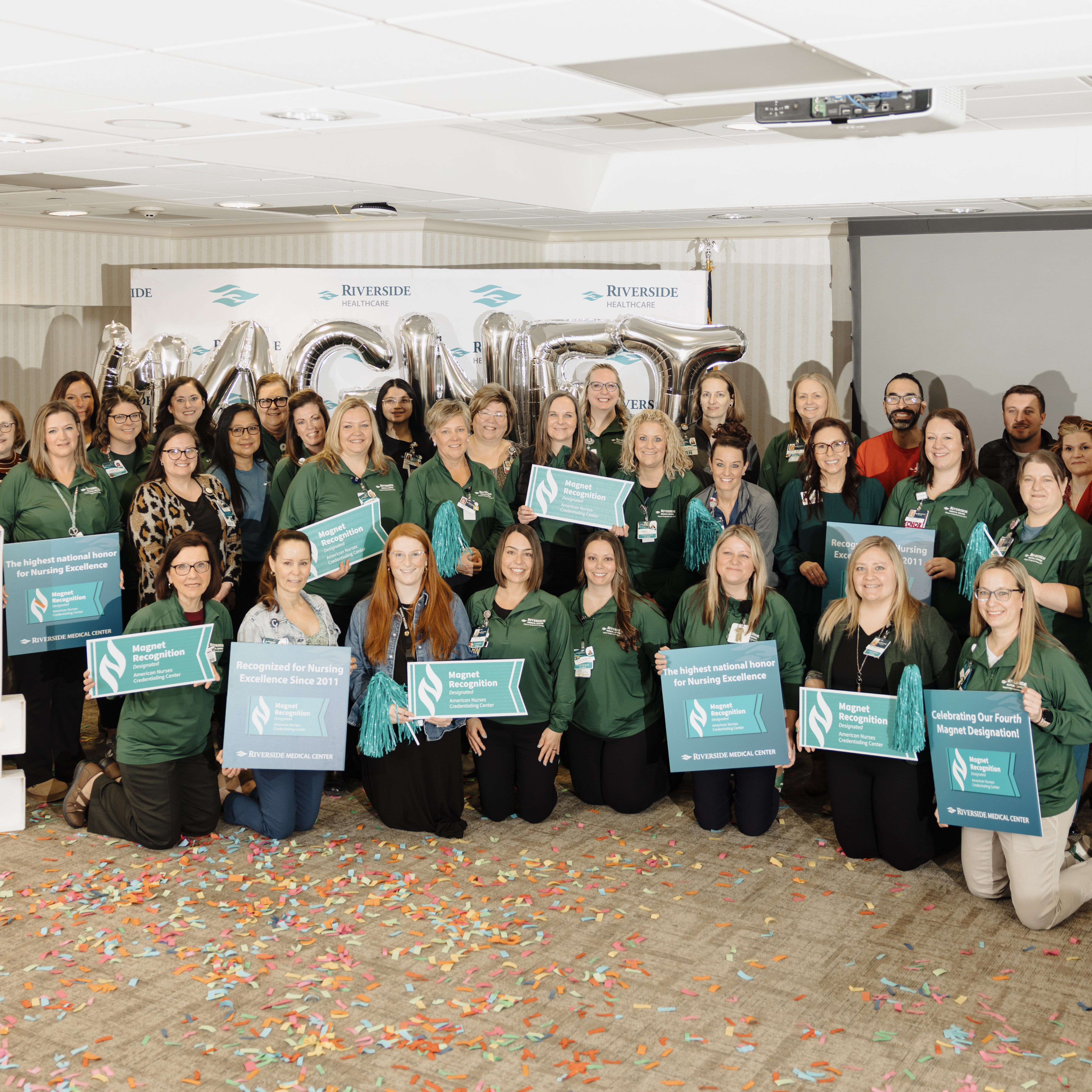 Riverside nurses holding Magnet Recognition signs while celebrating the hospital's fourth Magnet designation
