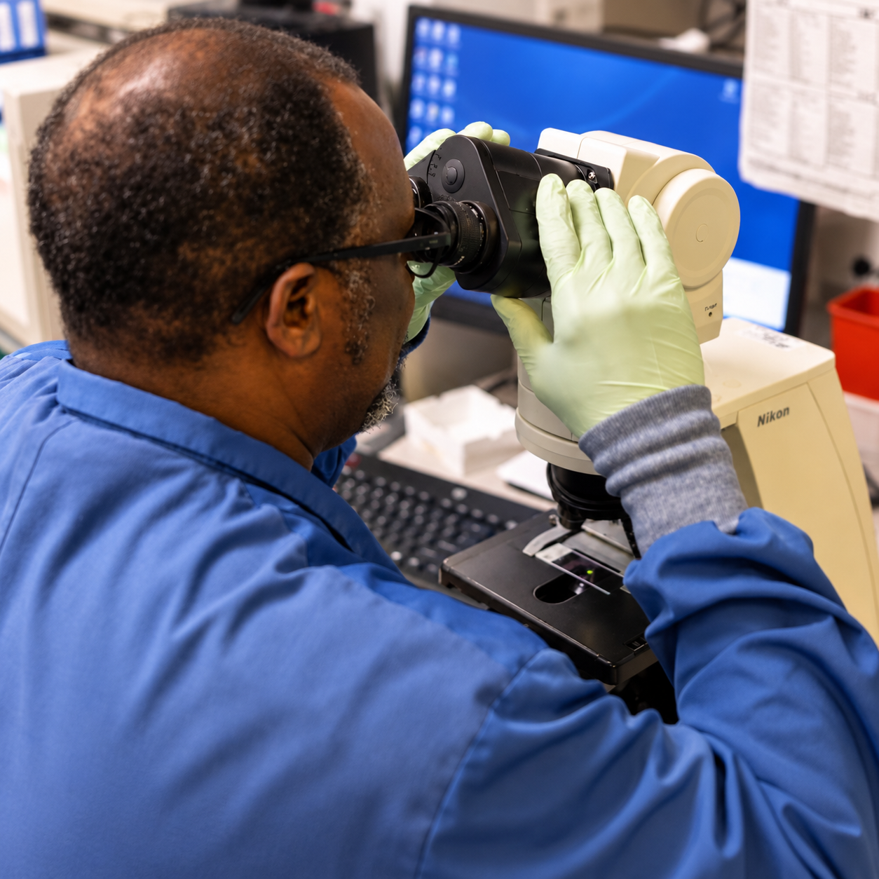 Riverside laboratory team member examining a sample under a microscope