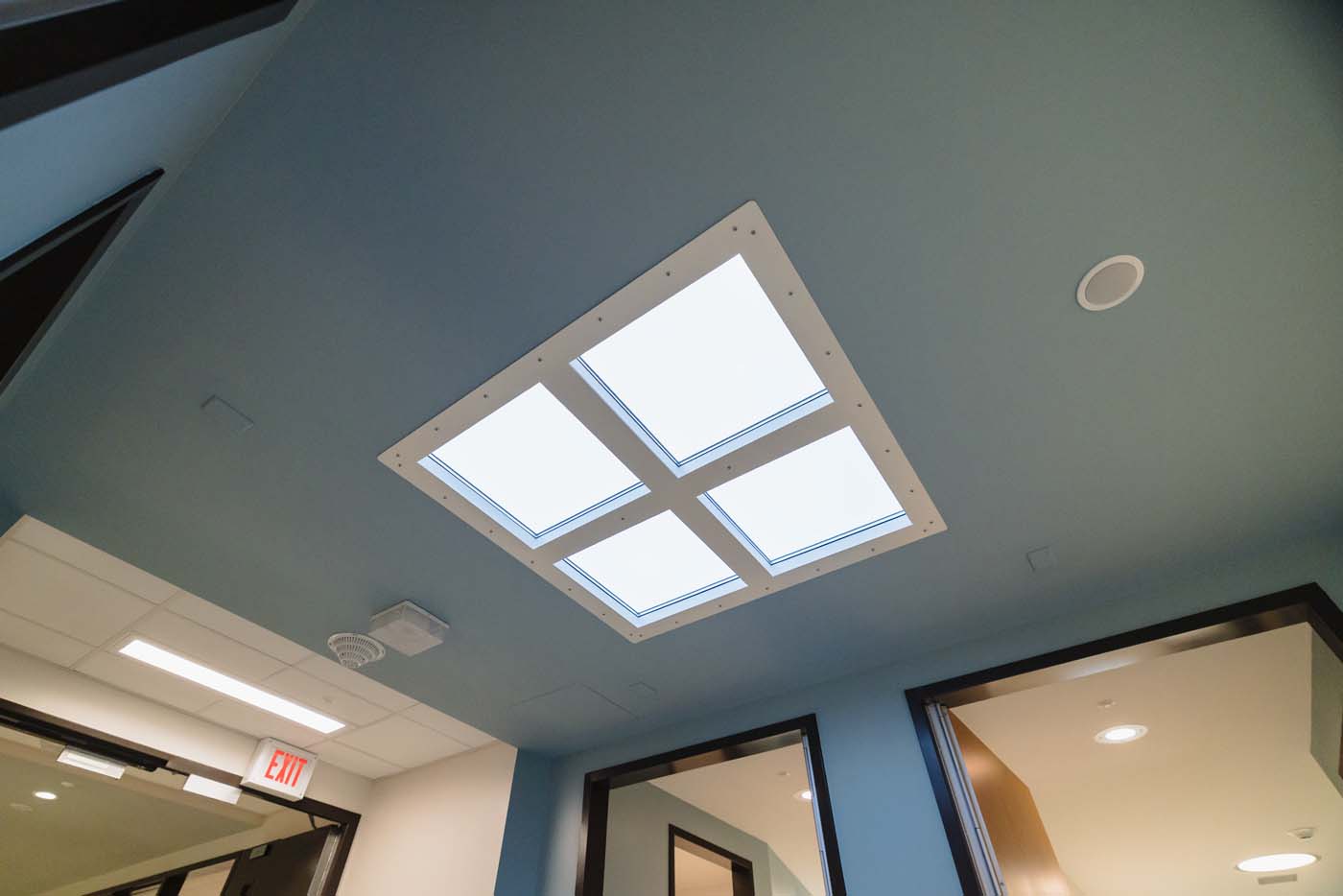 Ceiling light panel designed to mimic natural daylight in a unit hallway.