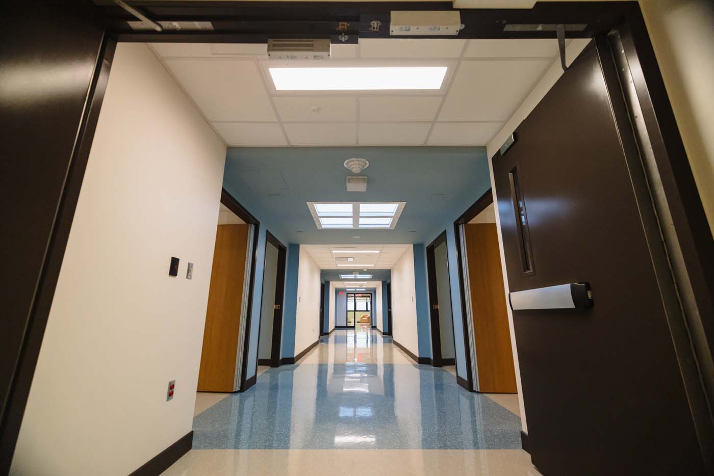 Unit hallway with color accents along the patient room doors.