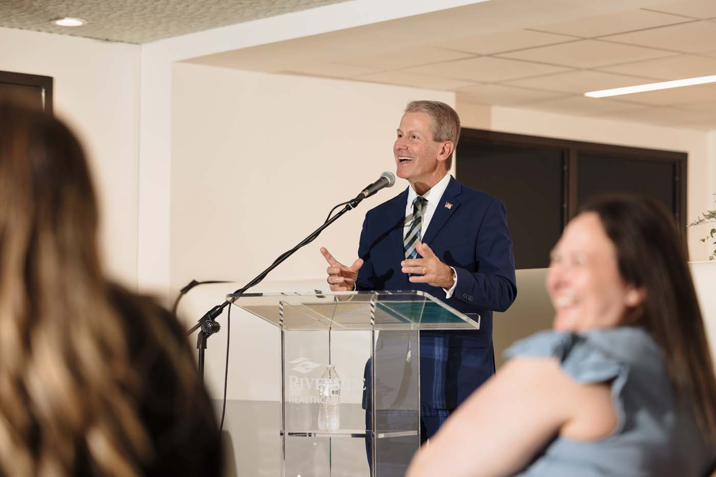 Phillip Kambic, Riverside Healthcare President and CEO, speaks at a podium during the opening event.
